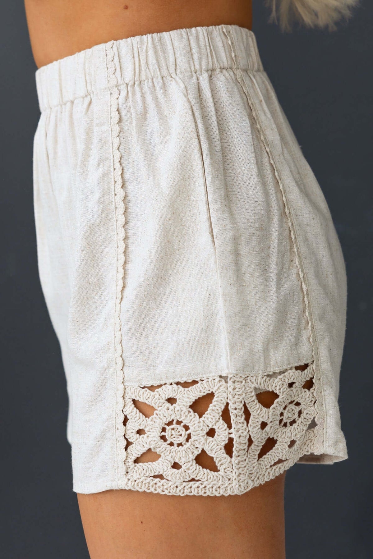 Rayner Shorts featuring mid-high waist, elastic waistband, pockets, and crochet detailing in a light fabric.