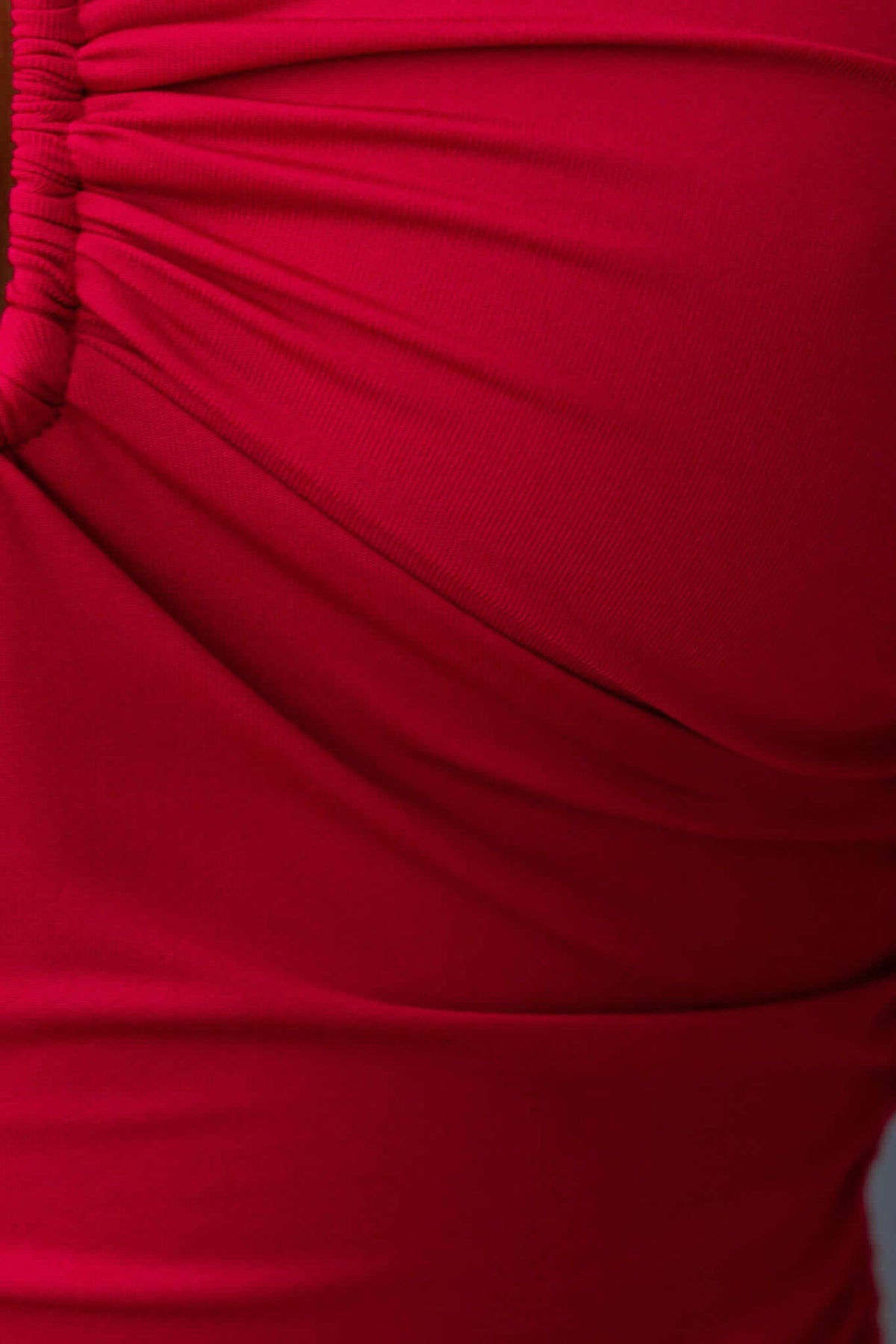 Close-up of the textured fabric of the Ablaze Bodysuit in vibrant red with ruching detail.