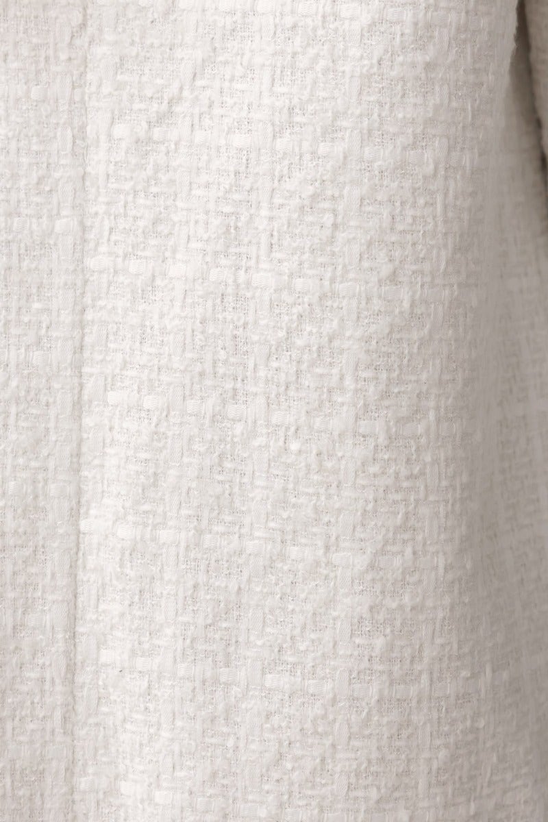 Close-up of Zadie Coat's textured tweed fabric, showcasing its elegant pattern and luxurious appearance.