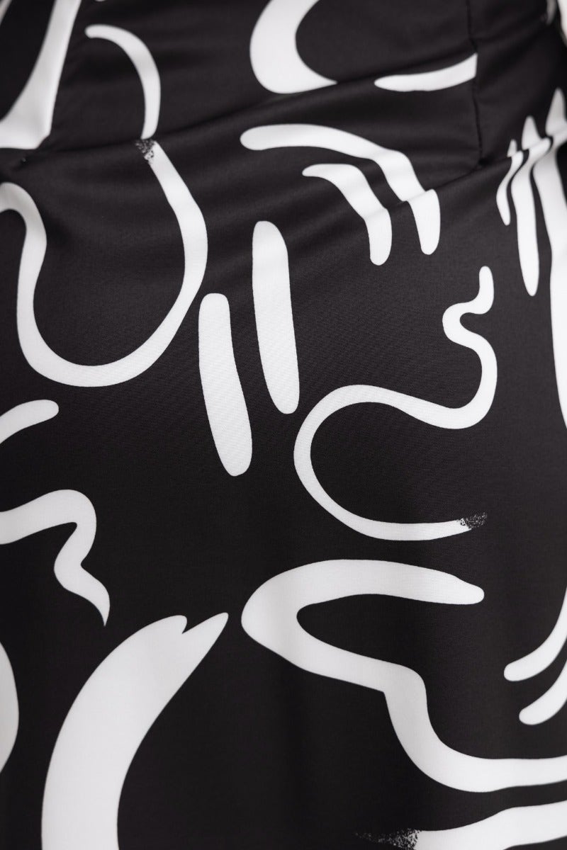 Close-up of the Yuliana Dress featuring a black base with white abstract print patterns, showcasing its unique design.