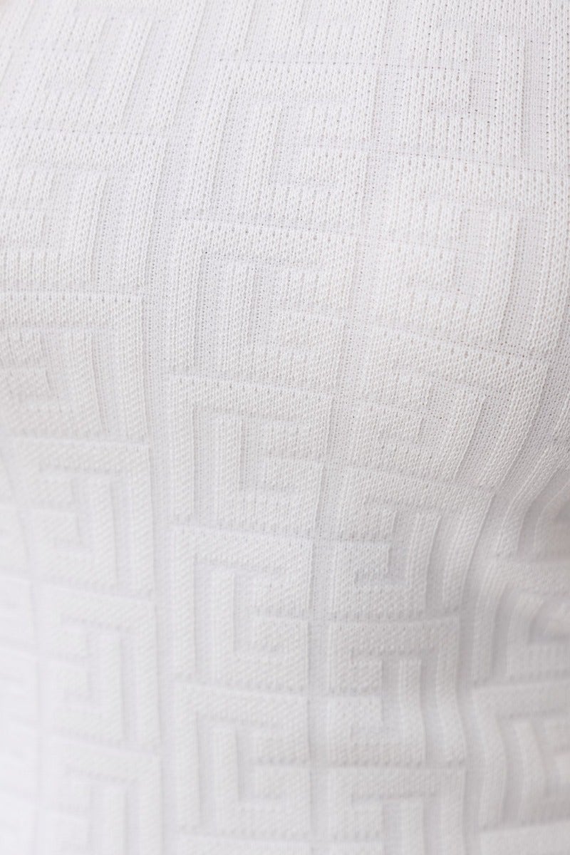 Close-up of white Uxbridge dress featuring embossed print and high neckline, showcasing its texture and stretch fabric.