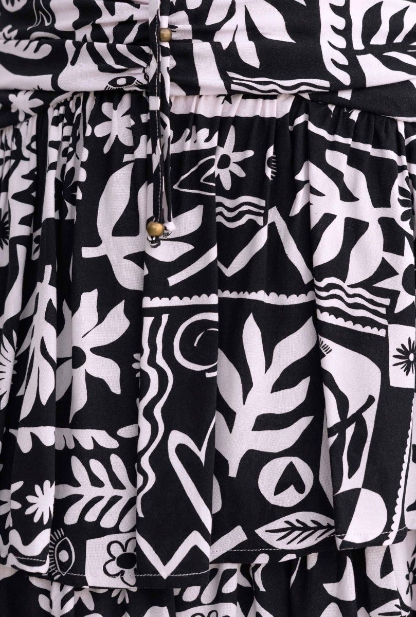 Close-up of black and white patterned fabric from Rynn Midi Dress, featuring ruffles and adjustable tie detail.