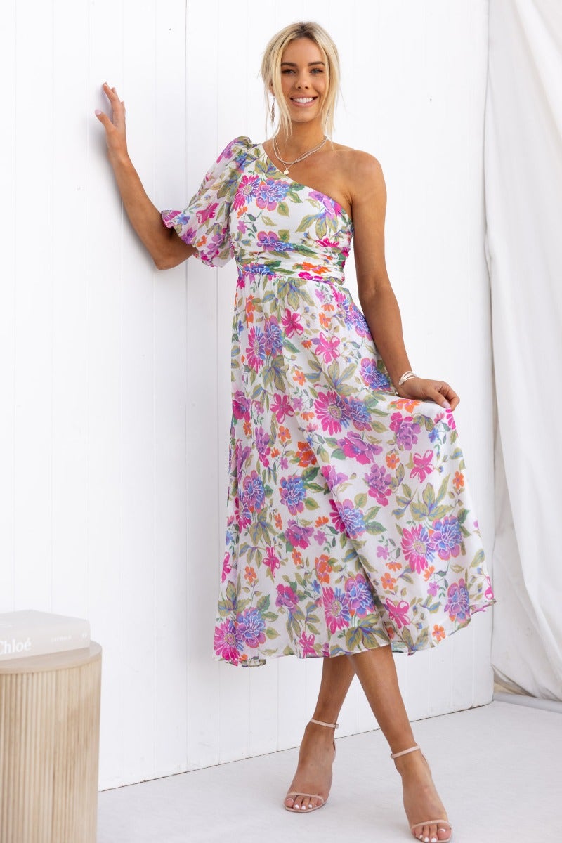 Model wearing a floral print Woran midi dress with one-shoulder neckline, styled elegantly against a white backdrop.