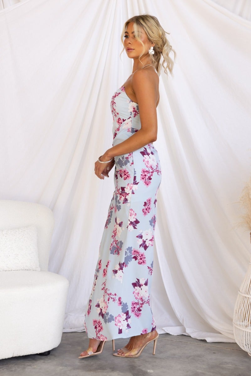 Elegant Tirana Maxi Dress featuring a floral print, strapless design, and front split, styled for a chic look.
