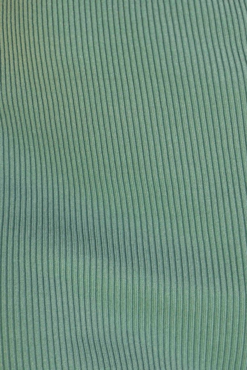 Close-up of ribbed knit fabric in green hues, perfect for creating cozy and stylish apparel.
