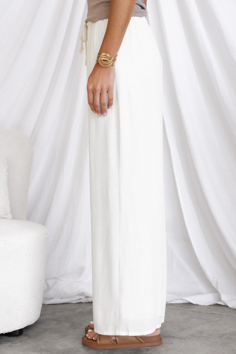 Side view of Corella Pants in white, showcasing their relaxed fit and lightweight fabric.
