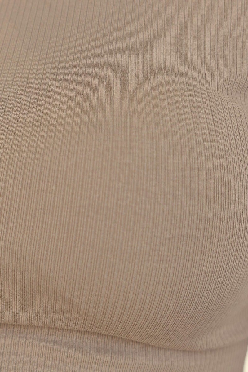 Close-up of Jett Top in ribbed beige fabric, showcasing the round neckline and stretchy material.