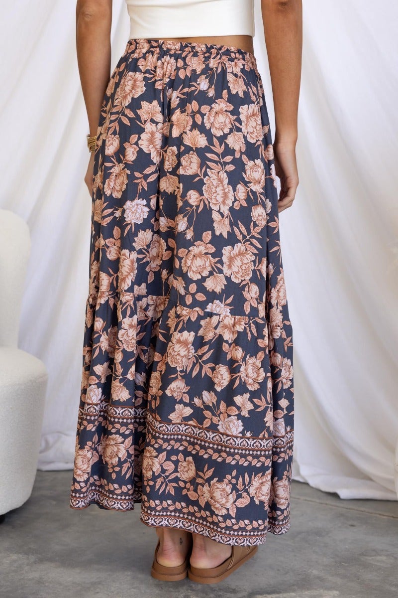 Navy floral print Qorri maxi skirt with elastic waistband and drawstring, featuring side splits and a relaxed fit.