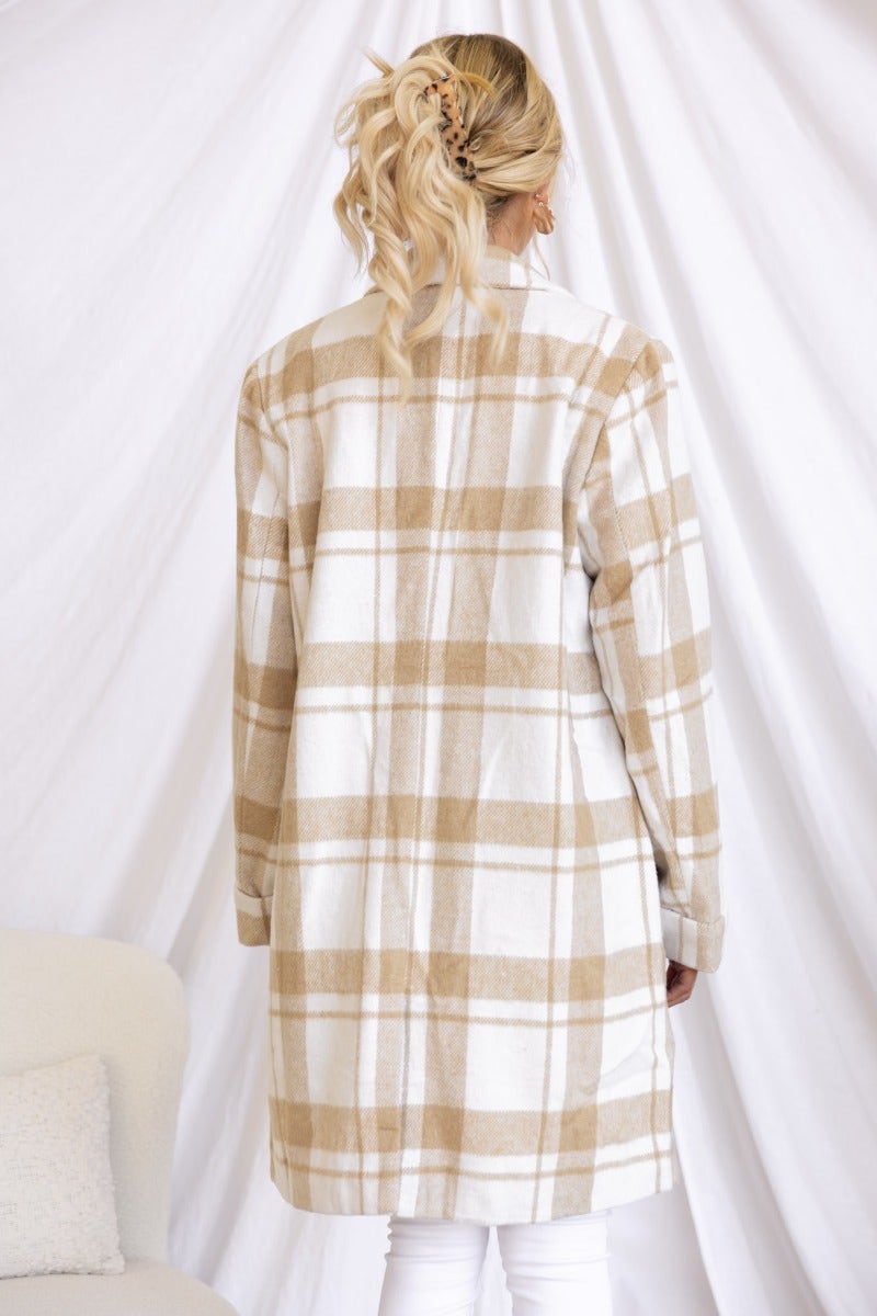 Back view of the Sabine plaid coat in beige and white, featuring faux pockets and a collar, styled with white pants.