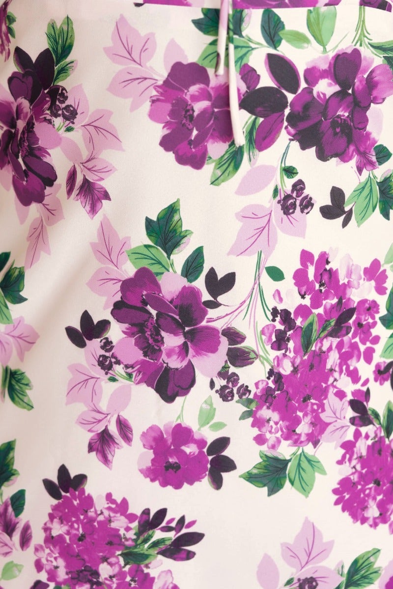 Close-up of vibrant floral print featuring purple and pink blooms on a cream background, perfect for a summer maxi dress.