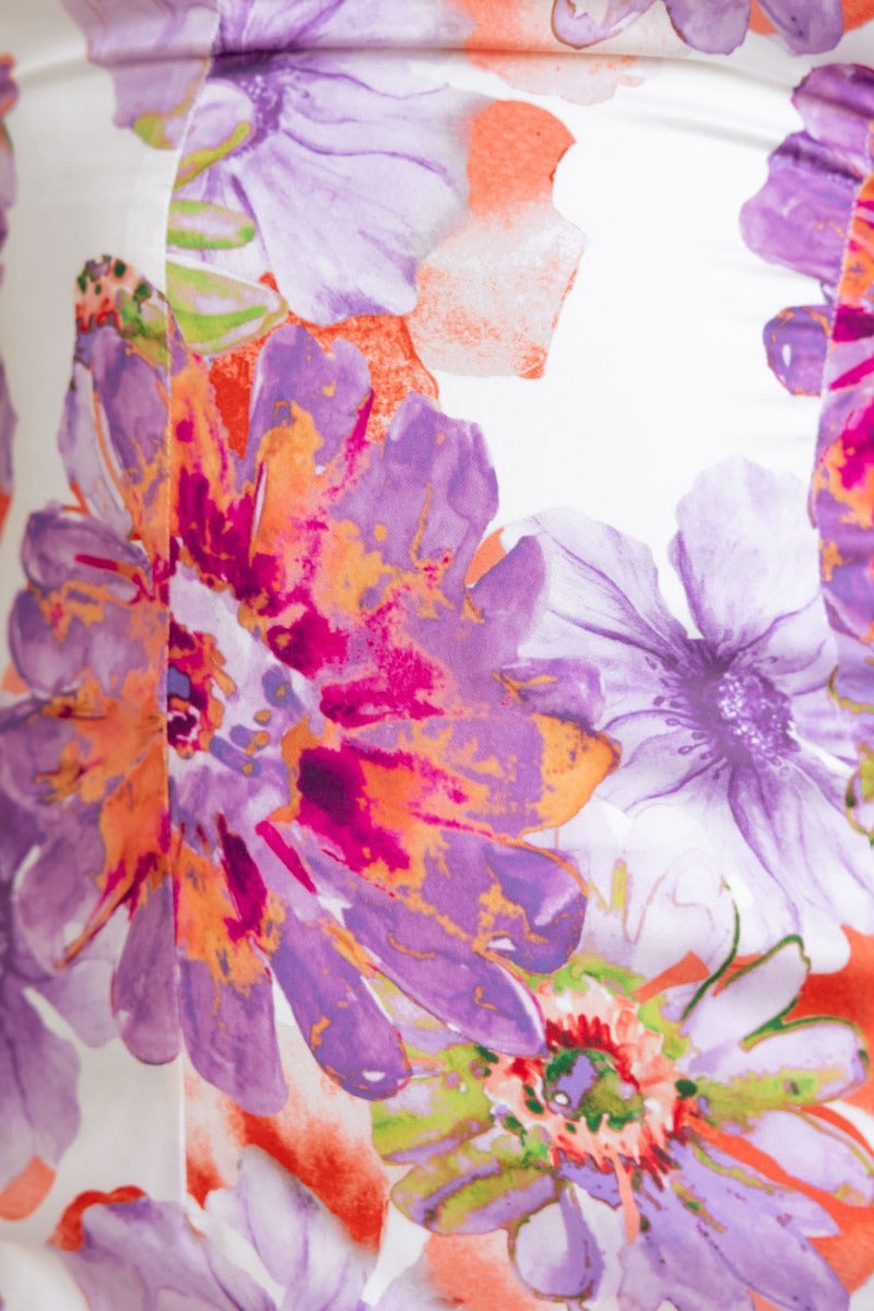 Close-up of vibrant floral print in shades of purple, orange, and white on Azarie Midi Dress fabric.