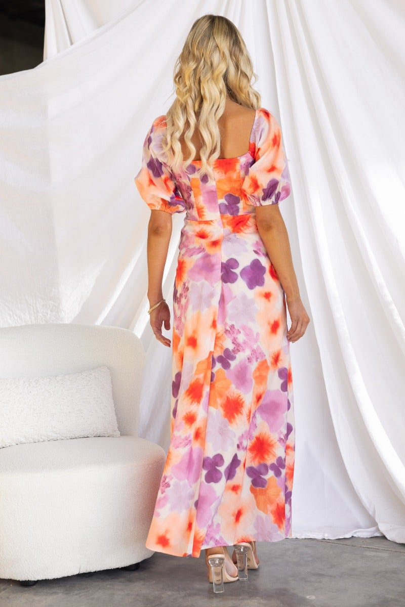 Back view of a floral print Eyre Maxi Dress with puff sleeves and a tie detail, showcased on a model.