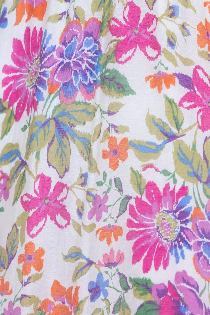 Vibrant floral print featuring pink, blue, and green flowers on a white background, perfect for a Woran Midi Dress.