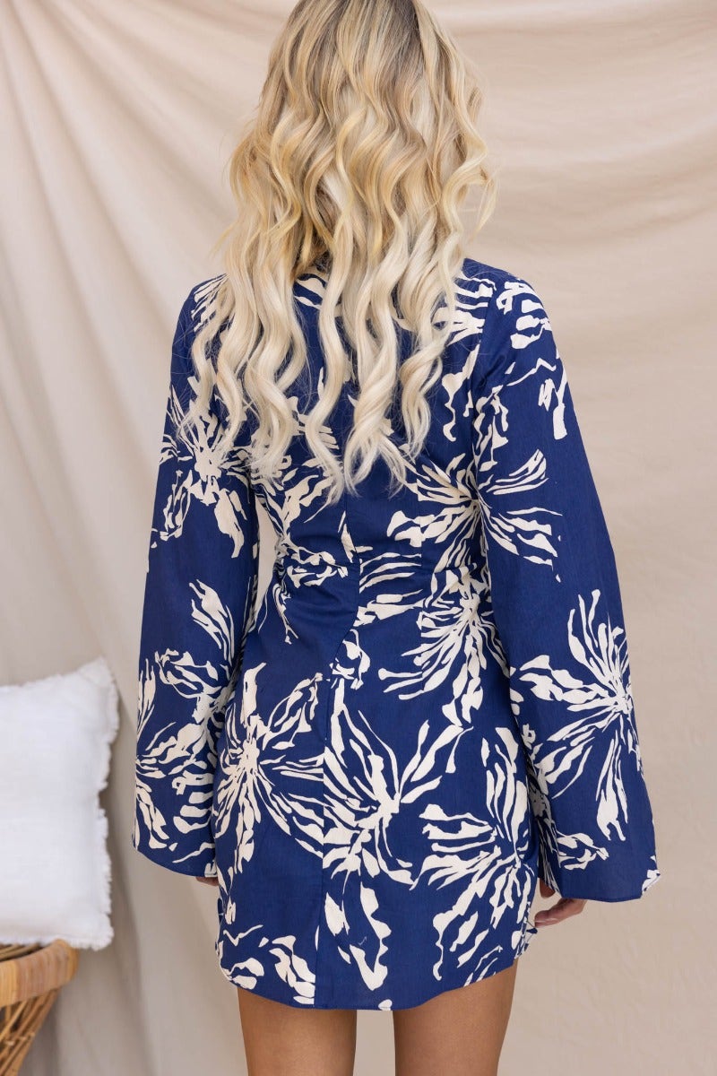 Back view of the Take Chances navy floral dress featuring a V-neckline and stylish bell sleeves.