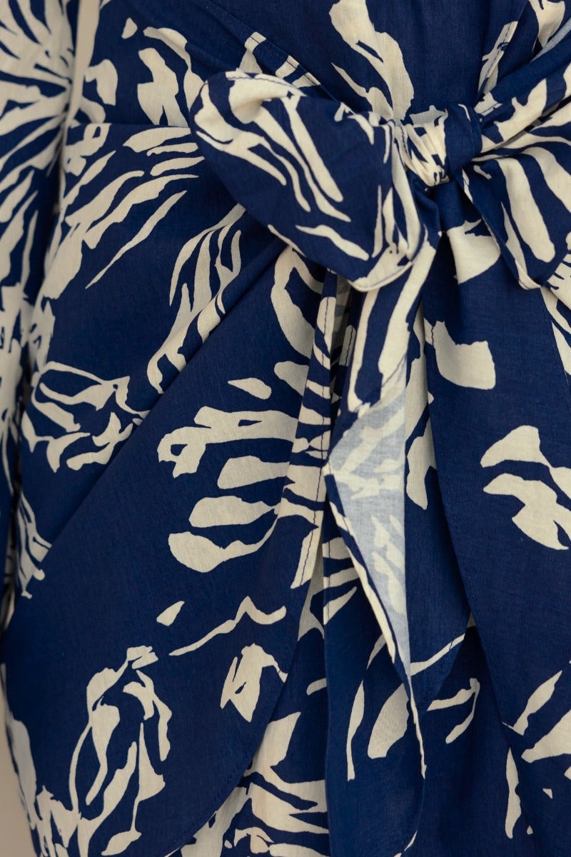 Close-up of the Take Chances Dress featuring a navy floral print and attached fabric tie detail.