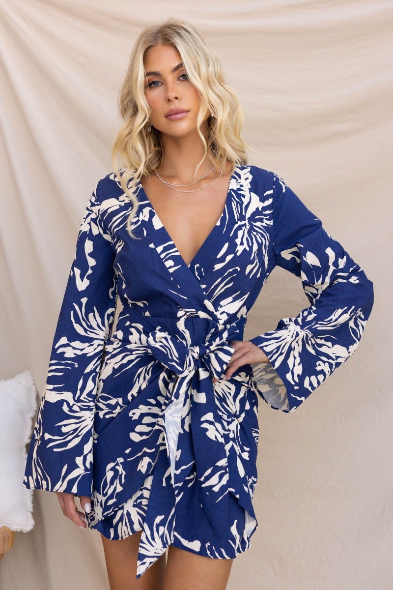 Navy floral print dress with V-neckline and tie, featuring bell sleeves and a stylish design for a chic look.