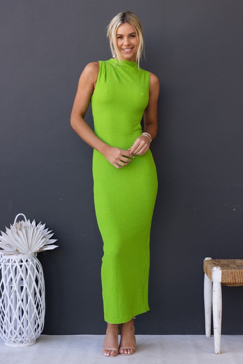 Model wearing a vibrant green textured maxi dress with a high neckline and cut-out waist, perfect for stylish summer outings.