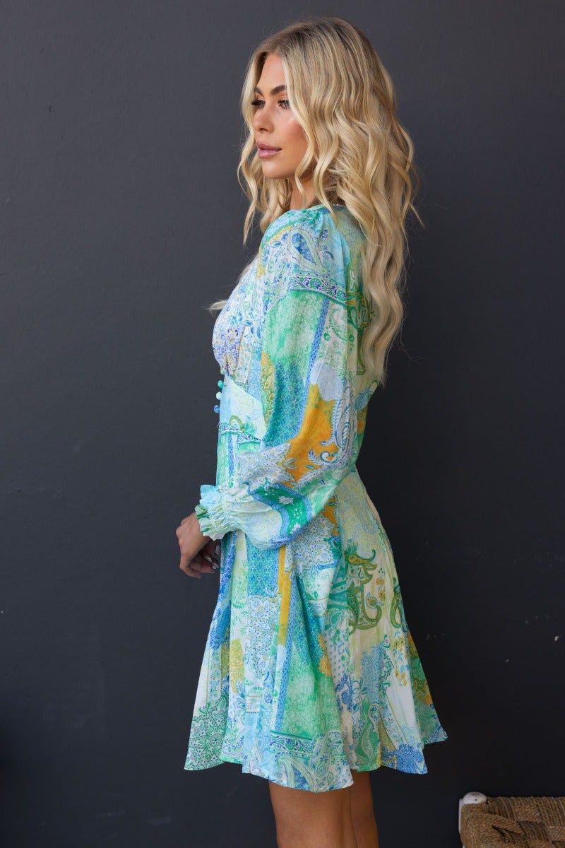 Side view of the Forever Glow multi-colour print dress with V-neckline and button detail.