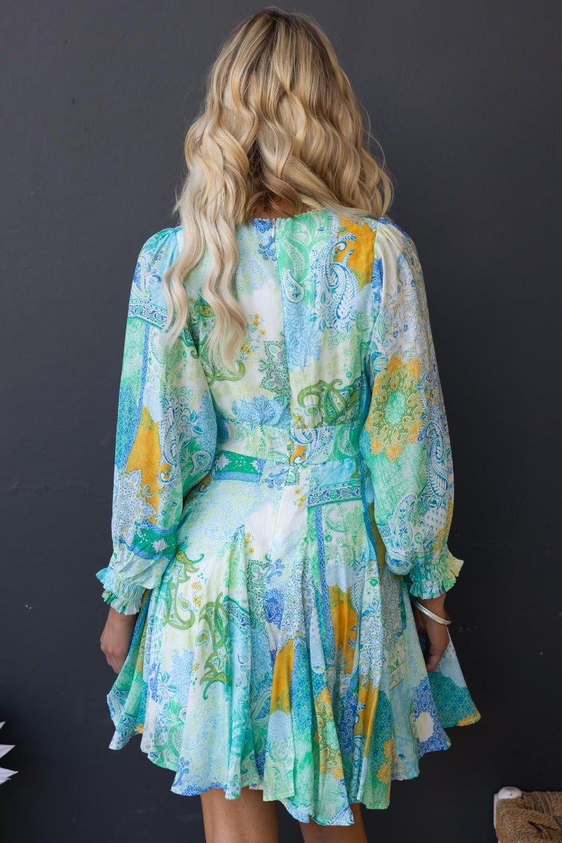 Back view of Forever Glow Dress featuring multi-color prints, V-neckline, and puff sleeves.