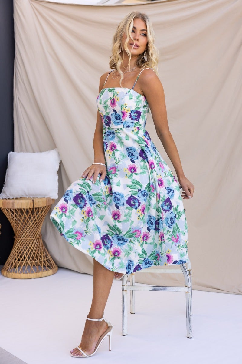 Model wearing a floral Rekiah midi dress with thin straps and square neckline, showcasing its vibrant design and fit.