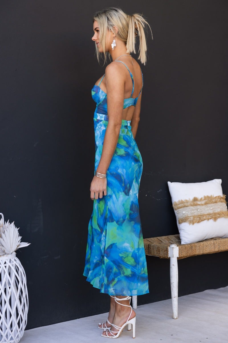 Side view of a model wearing the Rhai multi-colour print midi dress with adjustable straps and a flowing silhouette.