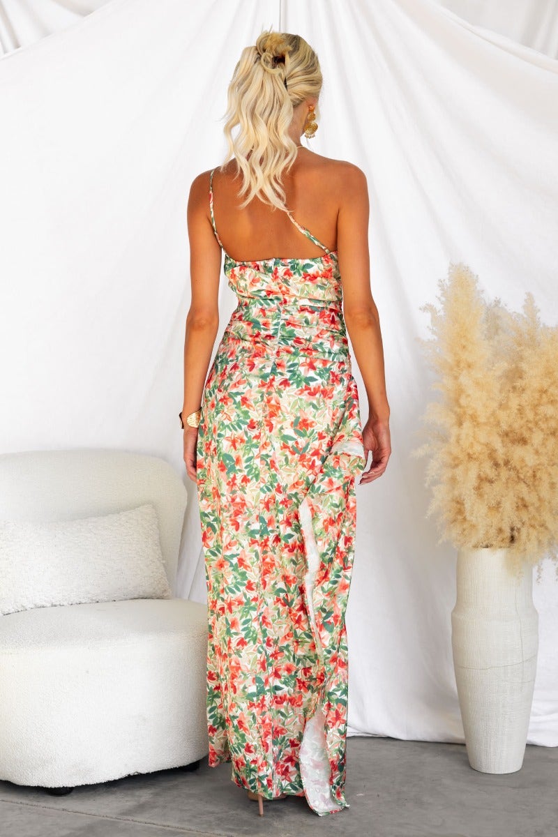Back view of Dimmi maxi dress featuring a floral print, one-shoulder neckline, and asymmetrical hemline.