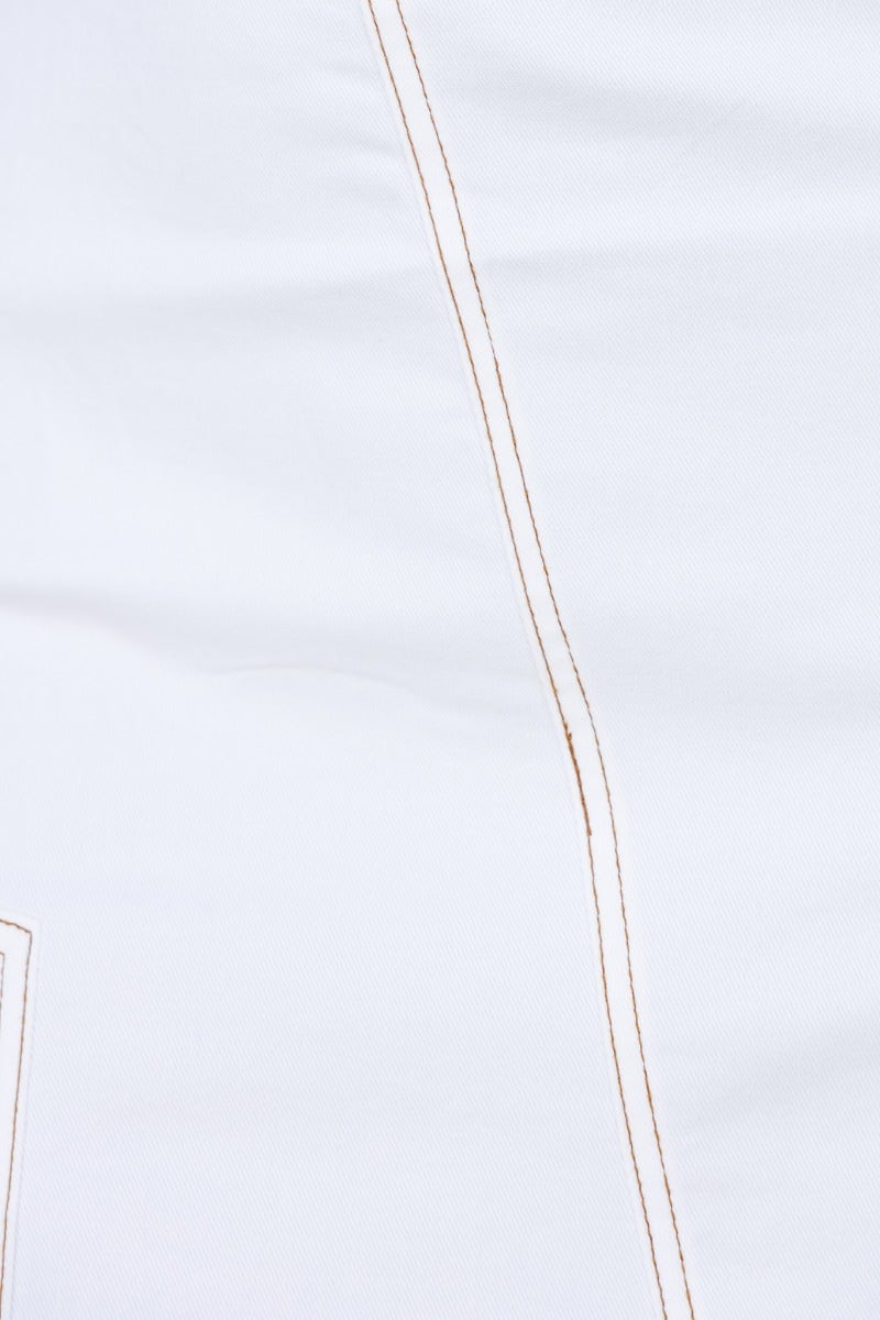 Close-up of white fabric with contrasting stitching detail, showcasing soft texture and quality craftsmanship.