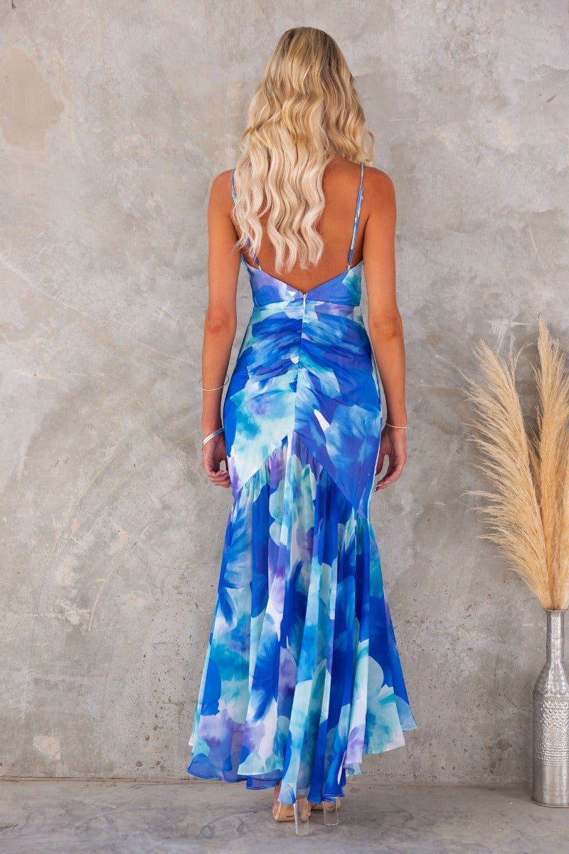 Blue floral print maxi dress with adjustable straps and flowy skirt, showcased from the back.
