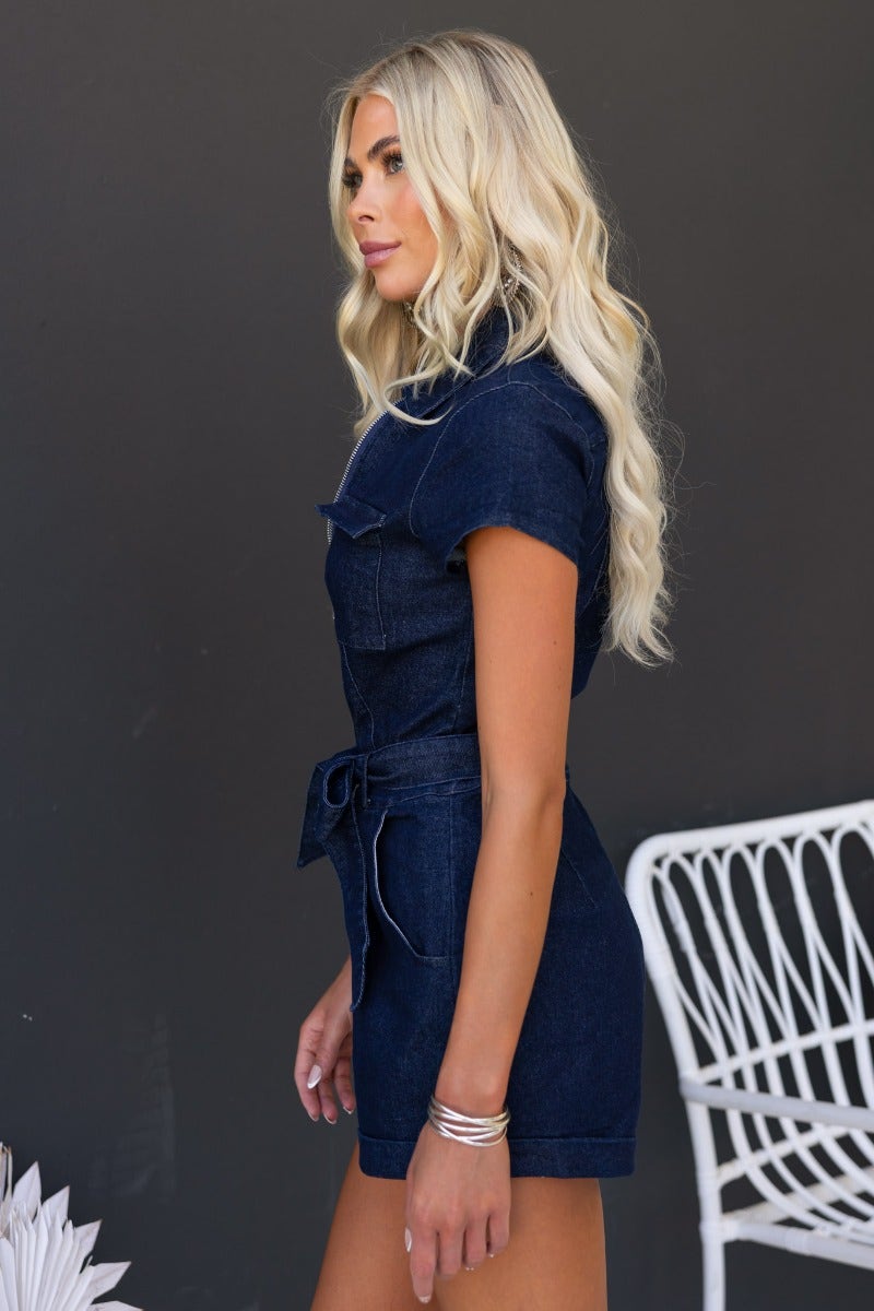 Model showcasing the Cobain Denim Playsuit with zip front, pockets, and removable belt in a stylish, casual pose.