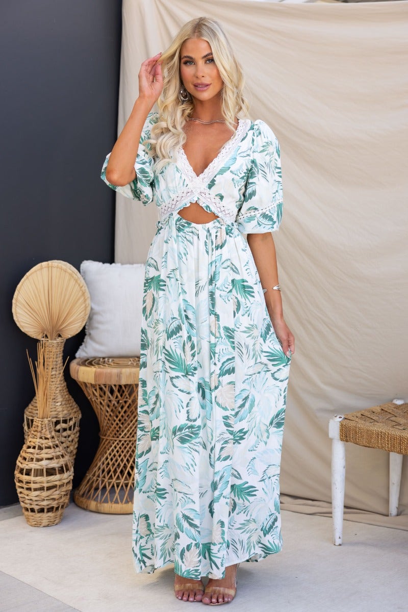 Out Of Sight Floral Print Maxi Dress with V-neckline and cut-out waist, styled in tropical setting.