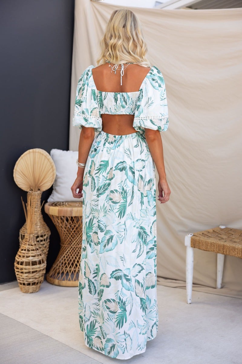 Back view of the Out Of Sight Maxi Dress featuring floral print, V-neckline, and cut-out waist with elastic sleeves.