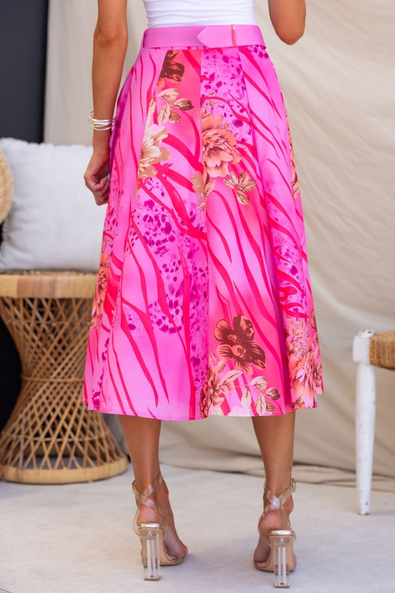 Back view of the optimistic floral print midi skirt in pink and fuchsia with a removable belt.