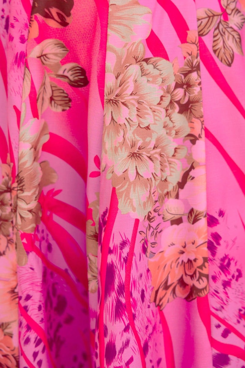 Close-up of floral print on a pink midi skirt featuring vibrant colors and intricate flower designs.