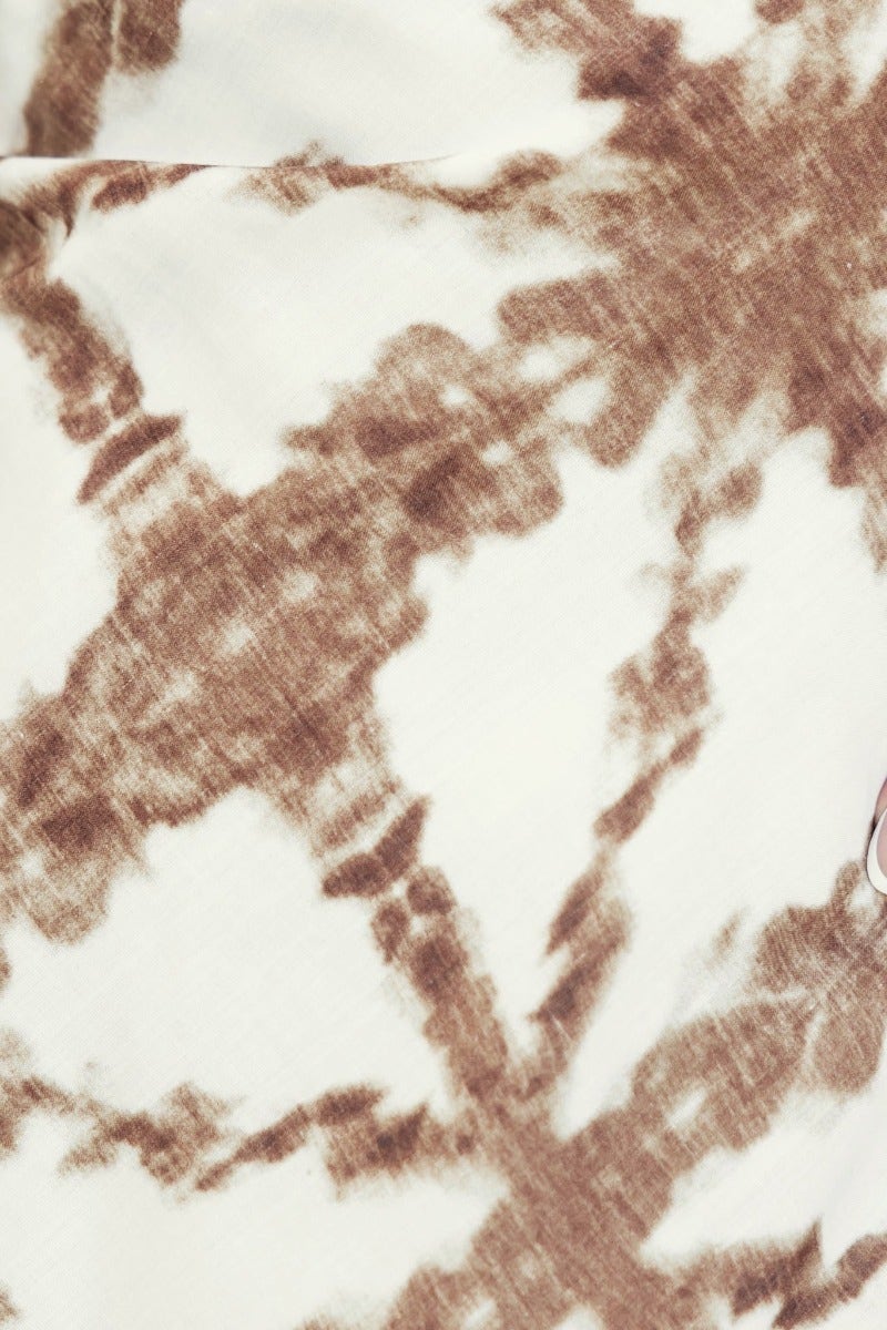 Close-up of a cotton blend fabric with a brown tie-dye pattern, showcasing texture ideal for a stylish maxi dress.