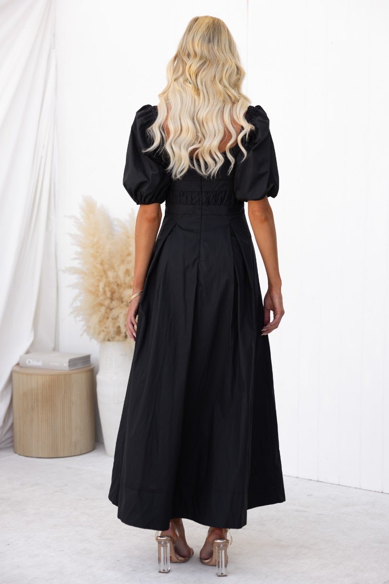 Back view of The Climb Maxi Dress in black cotton with puff sleeves and elegant fit.