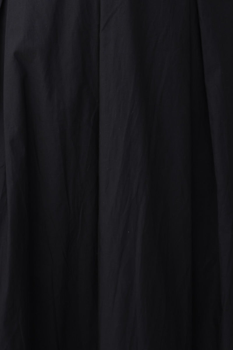 Close-up of the fabric of The Climb Maxi Dress in black cotton, highlighting texture and drape.