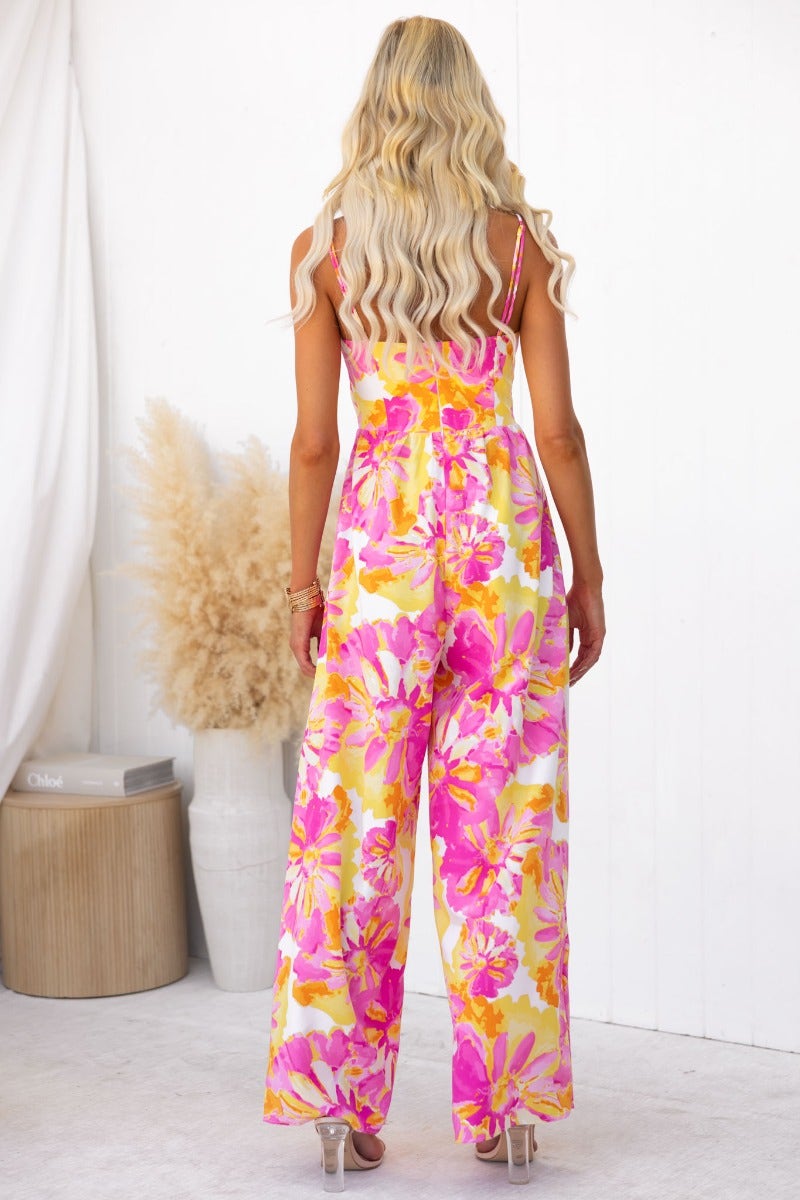 Back view of a floral print Ivy jumpsuit with adjustable straps and twist detail, perfect for summer fashion.