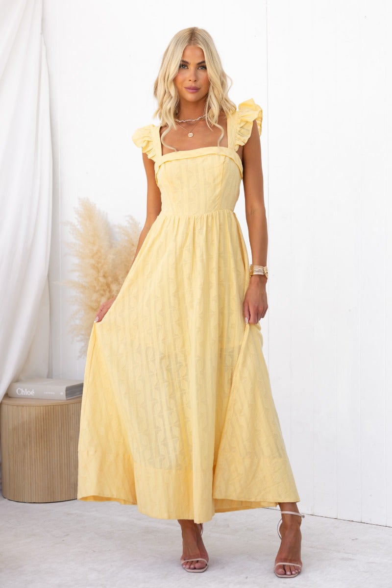 Fiji Maxi Dress in soft yellow, featuring ruffled straps and flowing design, perfect for summer occasions.