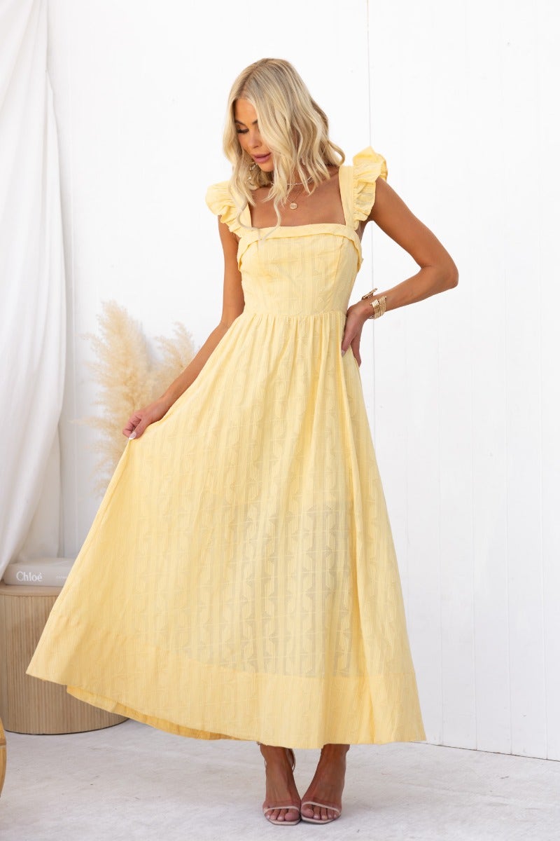 Model wearing a yellow textured maxi dress with ruffled sleeves and a flattering fit.