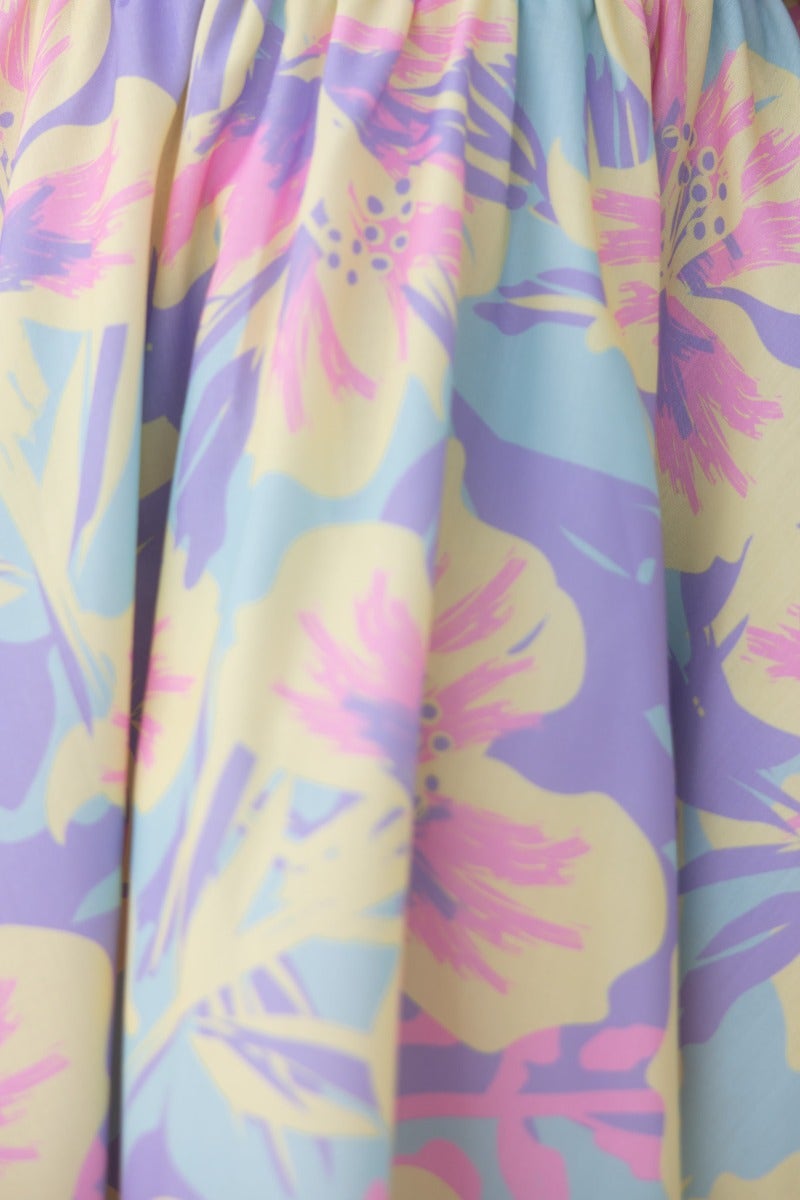 Close-up of colorful floral print fabric featuring pink, yellow, and blue hues for Claire Dress.