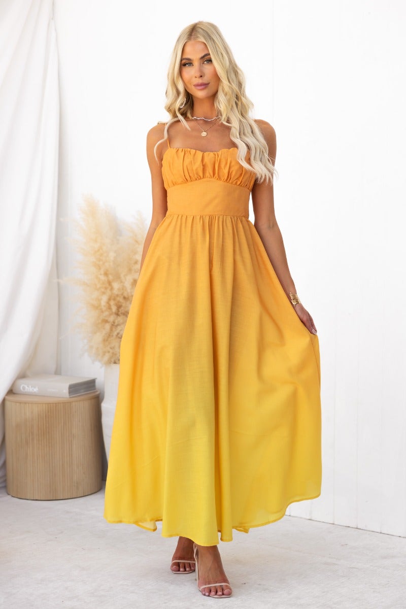 Model wearing a yellow cotton blend maxi dress with adjustable straps and a flowing design.