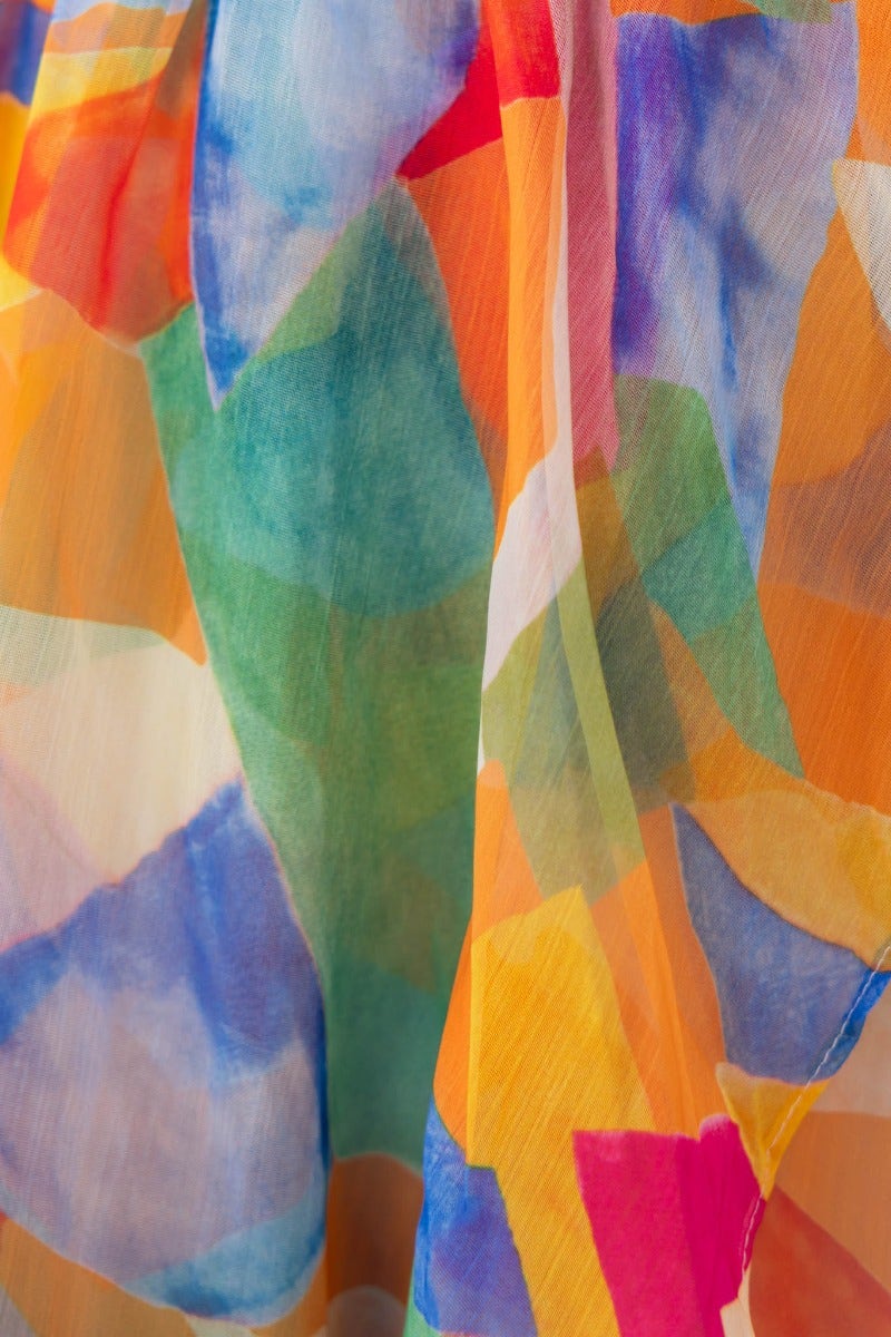 Close-up of colorful, abstract patterned fabric showcasing vibrant hues for a wrap dress.