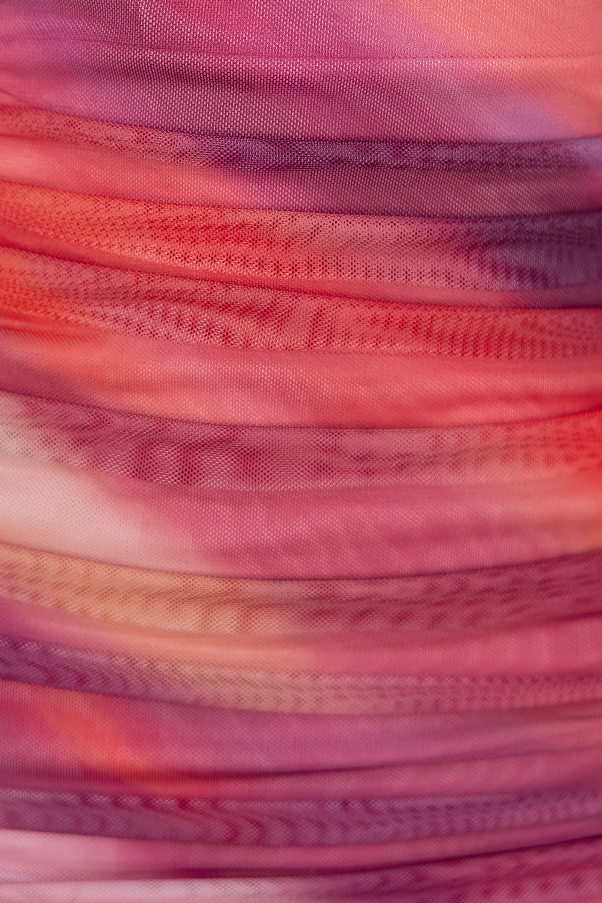 Close-up of ruched fabric in shades of pink and purple, showcasing texture and vibrant colors for the Dayara Midi Dress.