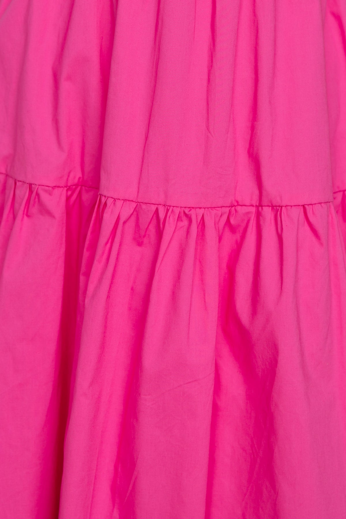 Close-up of vibrant pink fabric featuring gathered detailing on a Neisha Maxi Dress.