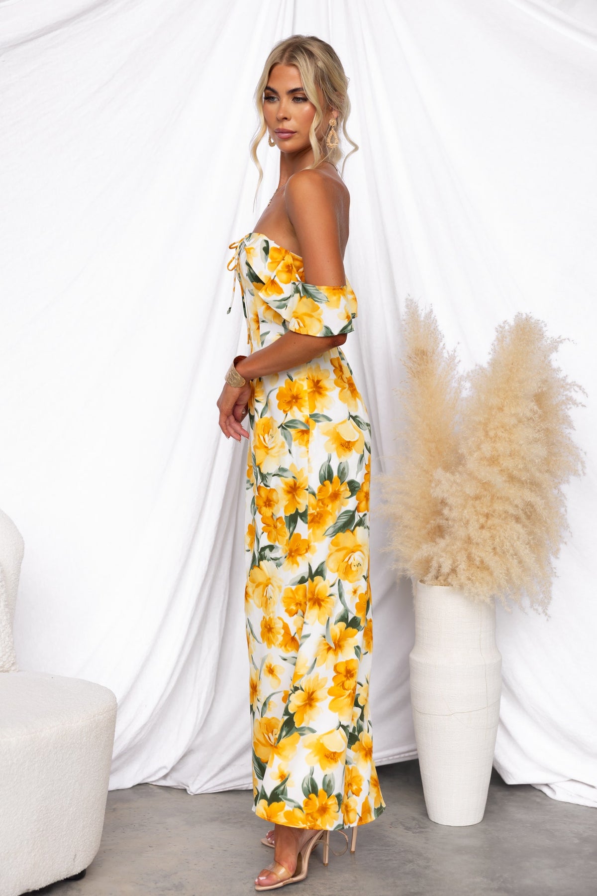 Model wearing floral print Take A Breath maxi dress with off-shoulder neckline and tie detail, styled with a neutral background.