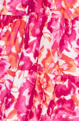 Close-up of floral print fabric in vibrant pink, orange, and white colors ideal for a maxi dress.