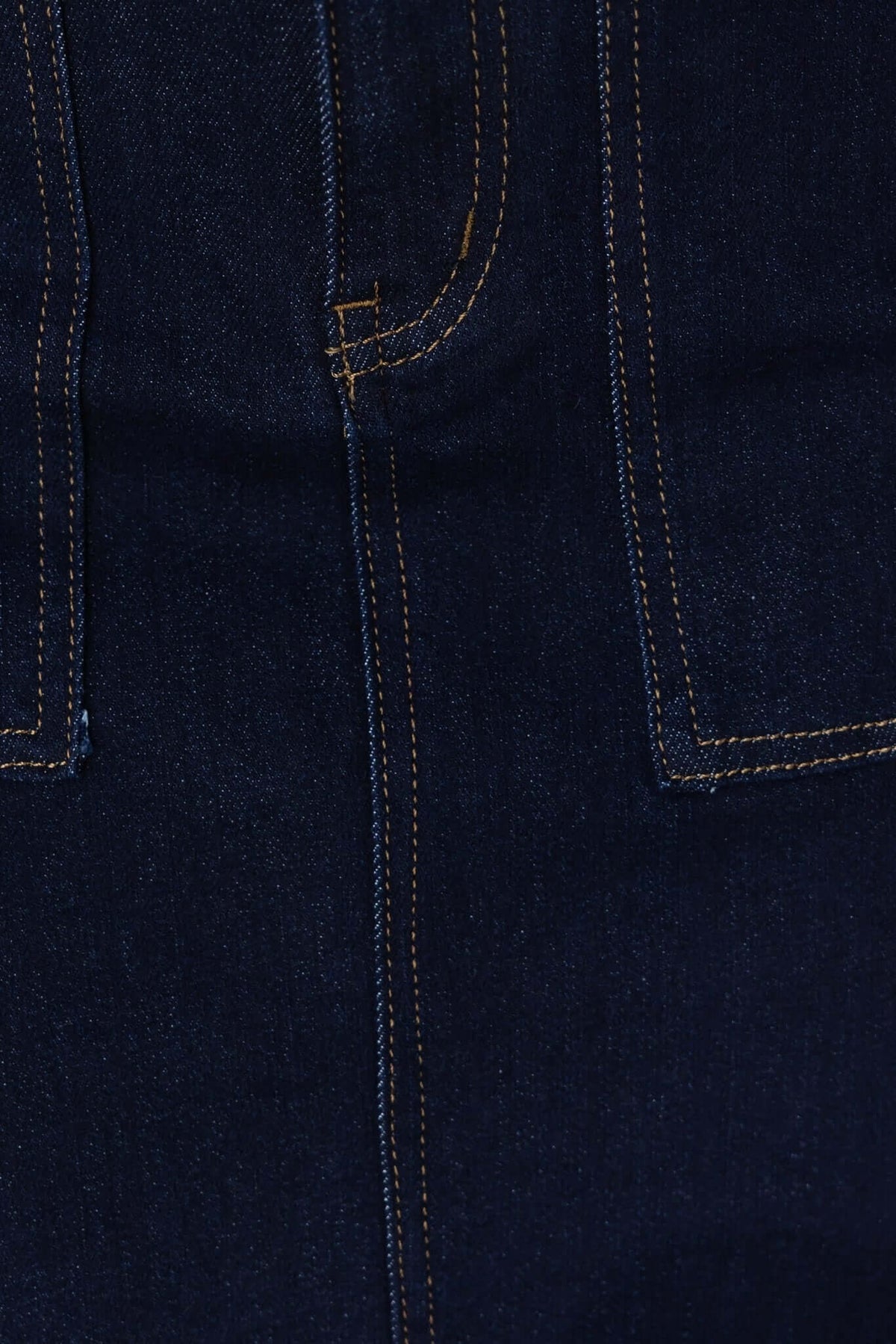Close-up of dark navy denim fabric showcasing pocket details of Ella Denim Midi Skirt.