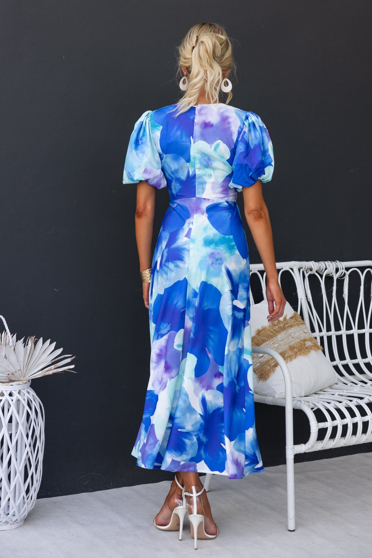 Model wearing Qeilor Midi Dress with floral print, V-neckline, and puff sleeves, showcasing a blue and purple color palette.