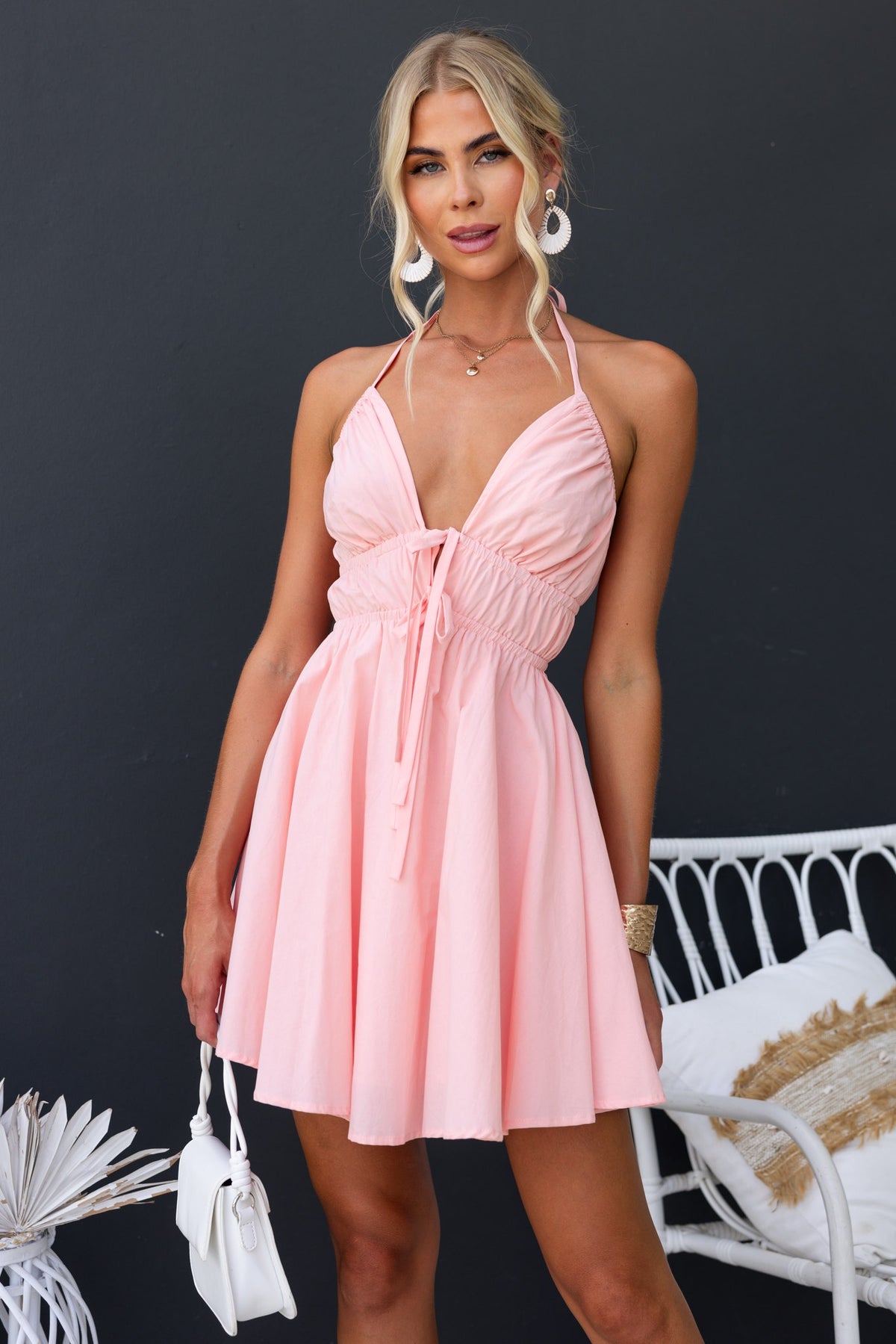Model wearing a pink Heart and Soul dress with adjustable tie neckline, showcasing a feminine and playful style.