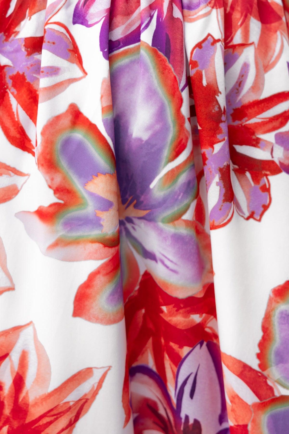 Close-up of vibrant floral print featuring red and purple flowers on a white background for a maxi dress.
